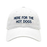 Embroidered white hat with "Here for the hot dogs" on a white background