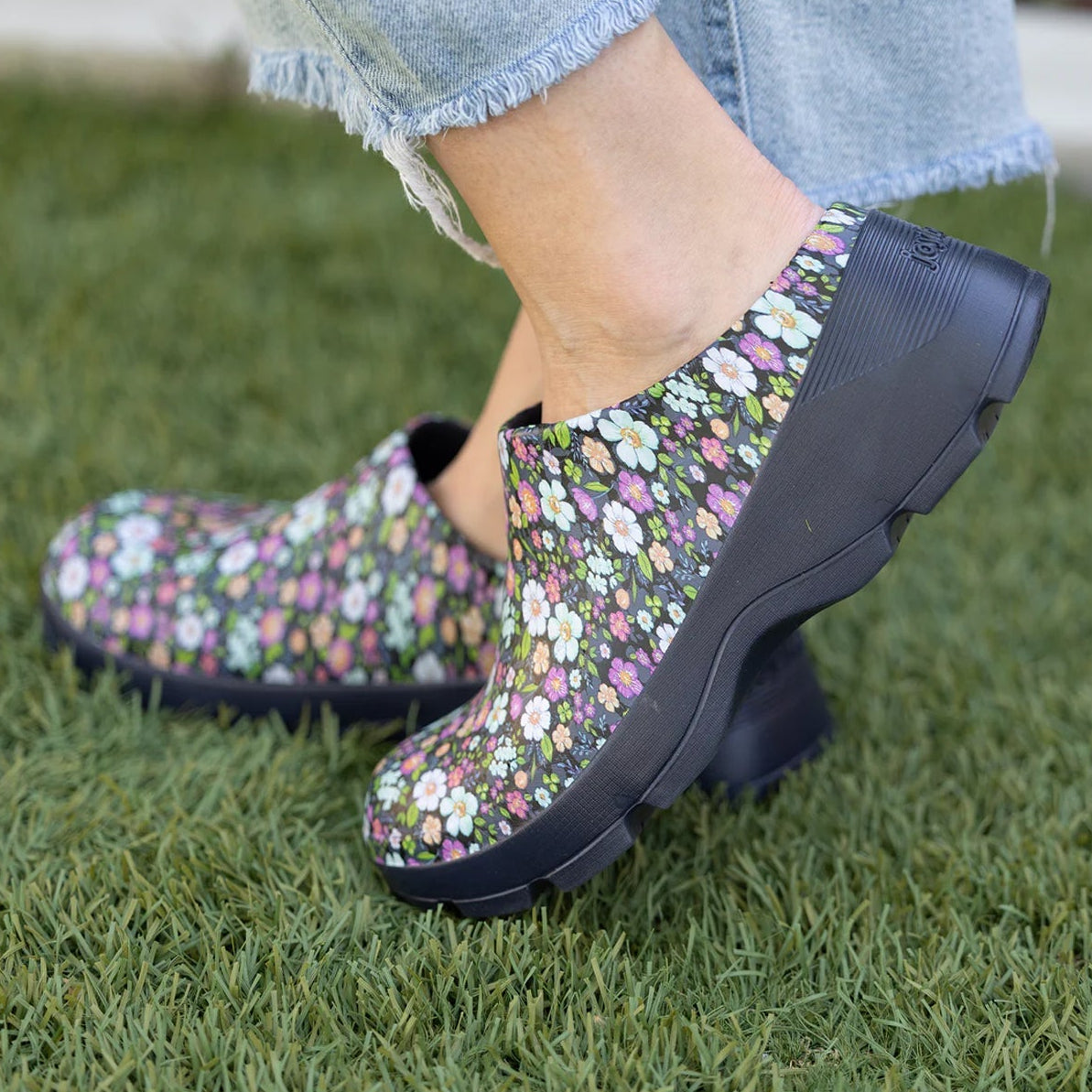 Floral-patterned rain boots on a person standing on grass