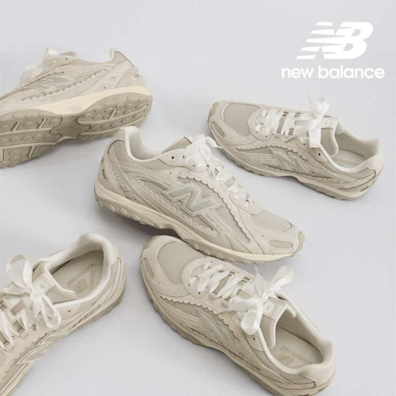 Beige sneakers with 'N' logo and white ribbon laces on grey background