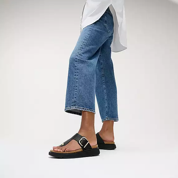 Black leather toe-post sandal with gold buckle. 