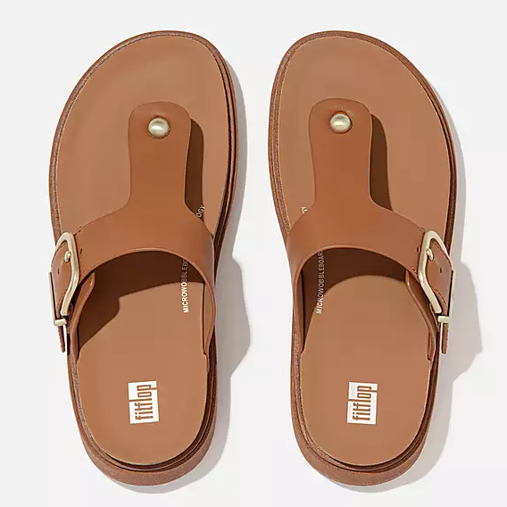 Light brown leather toe-post sandal with gold buckle. 