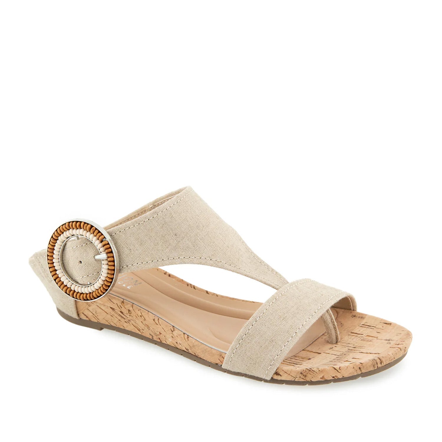 Beige fabric cork wedge toe-post sandal with oversized buckle.